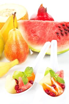 Fresh fruit pieces on two spoons, fruits in background isolated on white. Healthy background. In order to change we must be sick and tired of being sick and tired.