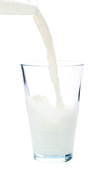 Pouring milk into a glass isolated on white background with clipping path.