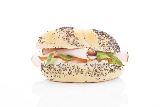 Poppy seed ham baguette with ham cheese and fresh herbs isolated on white. 