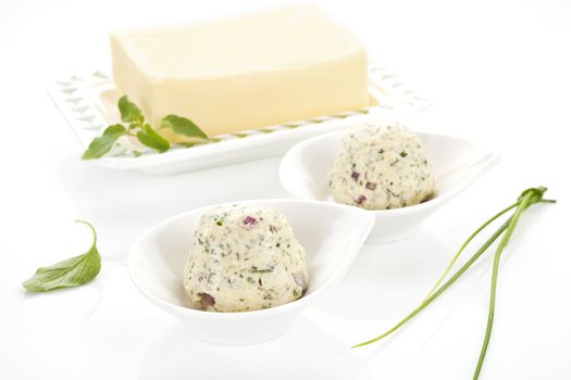 Diary product. Butter and herbal butter in two bowls isolated on white background with fresh herbs.