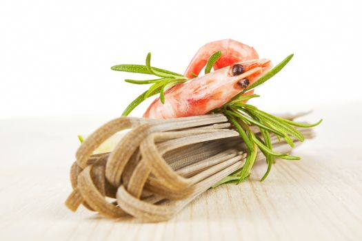 Gourmet seafood background. Pasta and prawn on wooden background. 