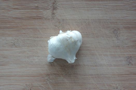 A clove of garlic on top of a cutting board