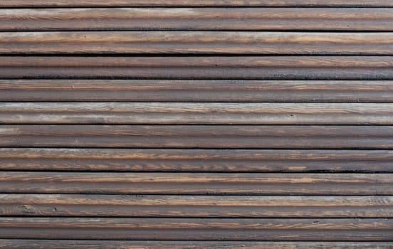 Wood background with horizontal dark brown, tarred planks.