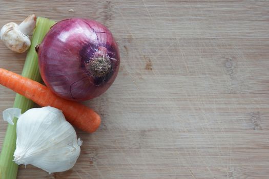 A group of vegetables on a wooden cutting board