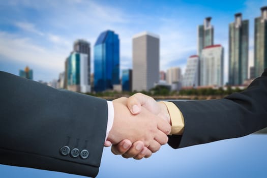 Businessman handshake with building area background
