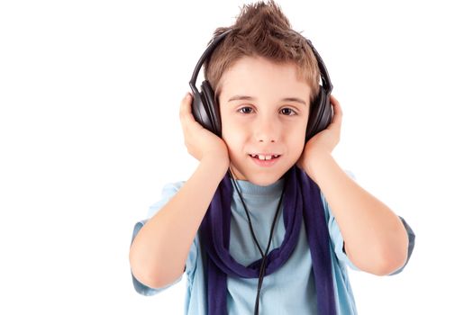 Cute little boy enjoying music using headphones over white background