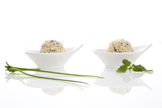 Herbal butter in two luxurious bowls isolated on white background with chive and herb.