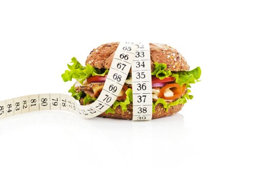 Healthy sandwich with fresh vegetables and cheese and measuring tape isolated on white. Fitness concept.