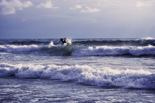 Surfer riding waves and pulling tricks on a beautiful day.