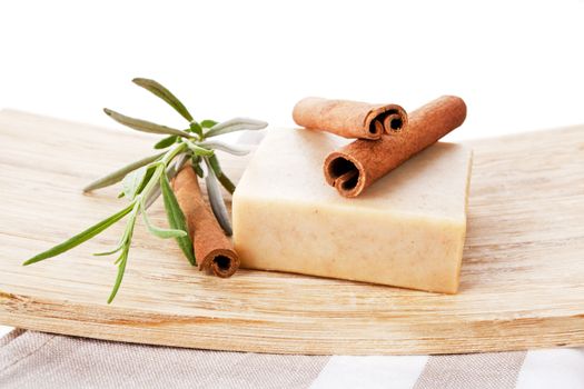 Beauty still life. Soap bar and cinnamon sticks decorated with fresh lavender isolated on white.