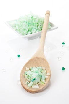 Bath salt on wooden spoon isolated on white. 