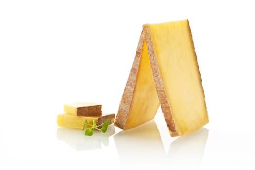 Luxurious cheese slices and pieces arranged on white background.