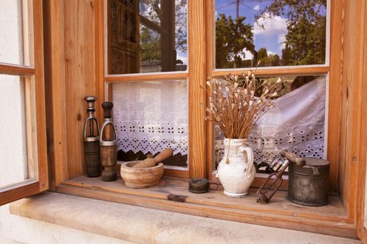 Traditional window in countryside with old vintage objects. Traditional farming still life.