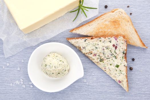 Luxurious breakfast. Toast with herbal butter, herbal butter in bowl and butter. Top view. Dairy products.