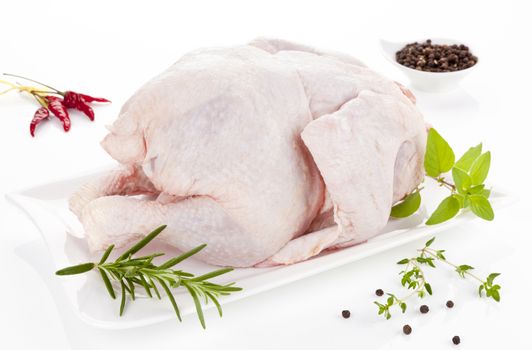 Fresh chicken decorated with herbs prepared for the oven. 