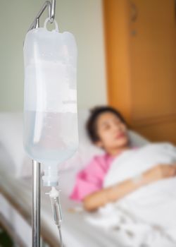 Infusion bottle with saline solution for patient in hospital room