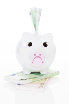 Sad piggy bank with tons of cash isolated on white background. Money does not make you happy.  concept.