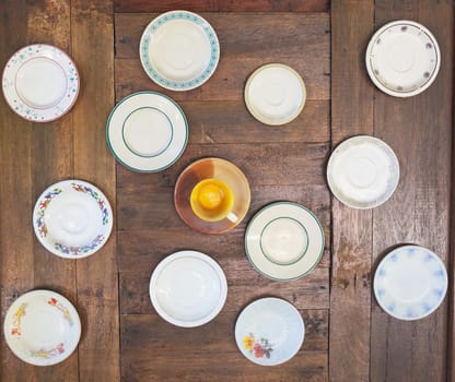 old empty plate and cup on wood wall, top view