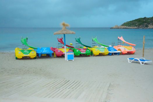 Empty beach with colorful toy water vehicles at Sant Elm, soon before the big storm on October 29 2013.