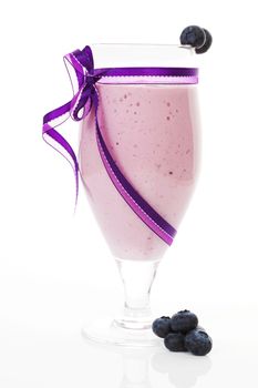 Delicious blueberry milkshake with fresh blueberries isolated on white background. Fresh summer beverages.