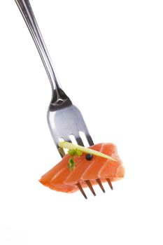 Salmon piece on fork isolated on white background. Culinary seafood eating.