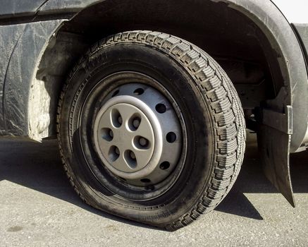 Flat tire on a truck, parked on asphalt in direct sunlight