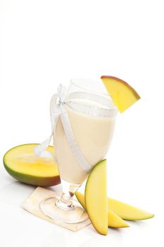 Delicious mango milk shake with fresh mango fruit isolated on white background. Refreshing summer drink.