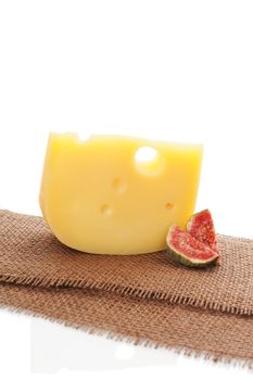 Swiss cheese emmentaler minimal sparse background with fig. Culinary cheese still life.