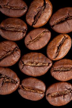 Delicious coffee beans isolated on black background. Top view. Culinary aromatic background.