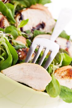 Fresh chicken salad with lamb's lettuce and chicken piece on silver fork. Diet summer healthy eating concept.