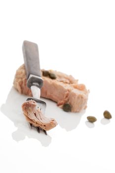 Delicious tuna steak on fork isolated on white background. Culinary fish eating.