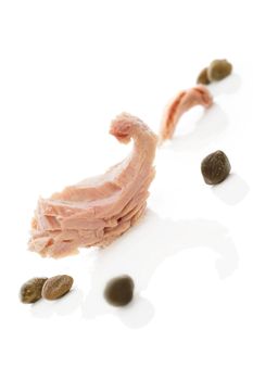 Luxurious seafood eating. Tuna piece with capers isolated on white background. Culinary healthy eating.