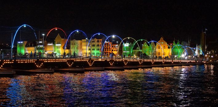 WILLEMSTAD, CURACAO - DECEMBER 10, 2013: Panorama of the Queen Emma Bridge in front of the Punda district at night on December 10, 2013 in Willemstad, Curacao, ABC Islands,