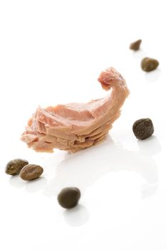 Tuna piece with capers isolated on white background. Culinary seafood eating.