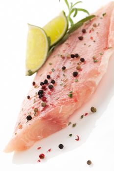 Delicious raw fish fillet with lime, fresh herbs and colorful peppercorns. Culinary seafood eating. 