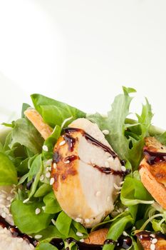 Delicious fresh summer salad with poultry pieces, sesame and field salad. Summer food background. 