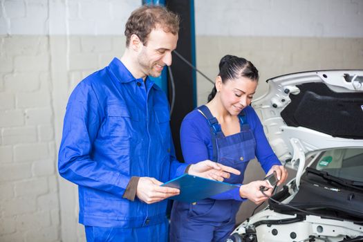 Car mechanics repairing car electrics and other parts of the motor