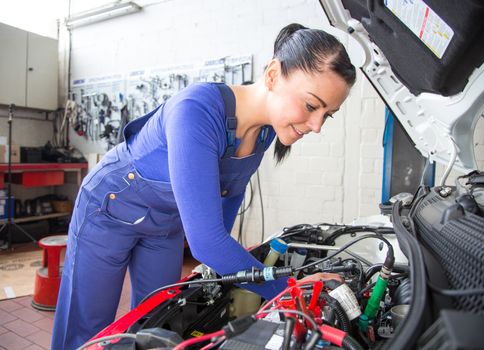 Car mechanic repairing a automobile in a garage or workshop