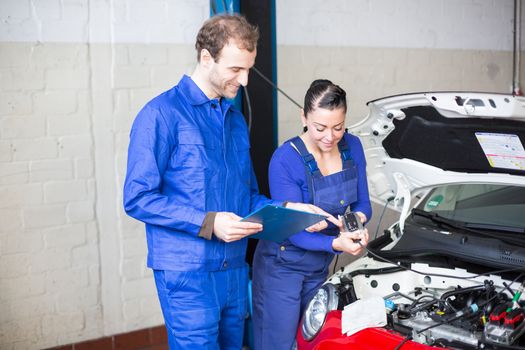 Car mechanics repairing car electrics and other parts of the motor