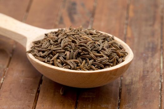 cumin seeds in wooden spoon