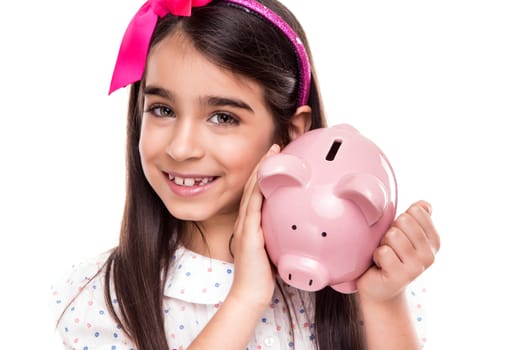 Young girl holding a piggy bank over white background