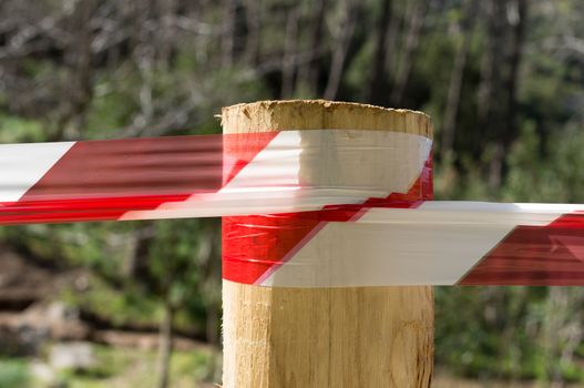 Warning tape attached to a wooden pole and used as a parapet