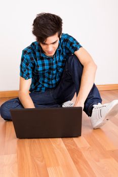 Young man working on computer laptop at home