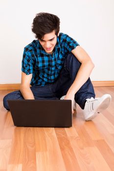 Young man working on computer laptop at home