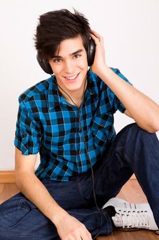 Young man listening music with headphones at home