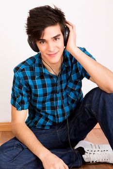 Young man listening music with headphones at home