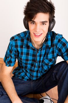 Young man listening music with headphones at home