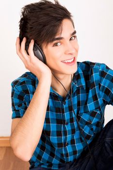 Young man listening music with headphones at home