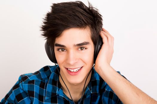 Young man listening music with headphones at home