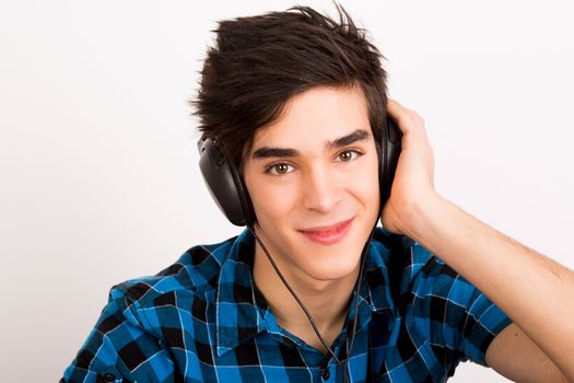 Young man listening music with headphones at home